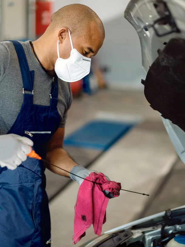 Service Tech Wearing Face Mask Completing Oil Level Check